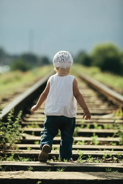 Liten flicka spelar på järnvägen — Stockfoto