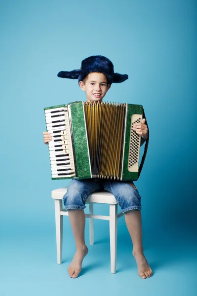 Little accordion player on blue background — Stock Photo, Image