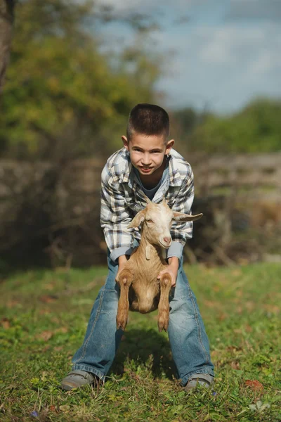 Маленький мальчик с козой на ферме — стоковое фото