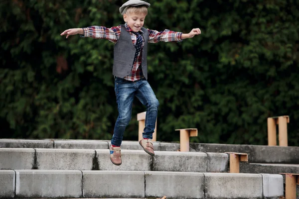 Liten pojke hoppar på trappan — Stockfoto