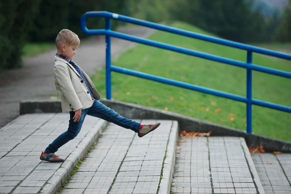 Liten pojke hoppar på trappan — Stockfoto