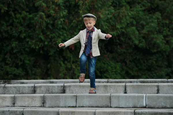 Liten pojke hoppar på trappan — Stockfoto