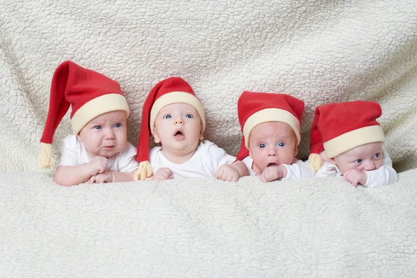 Bebeluși cu pălării Moș Crăciun pe fundal luminos — Fotografie, imagine de stoc