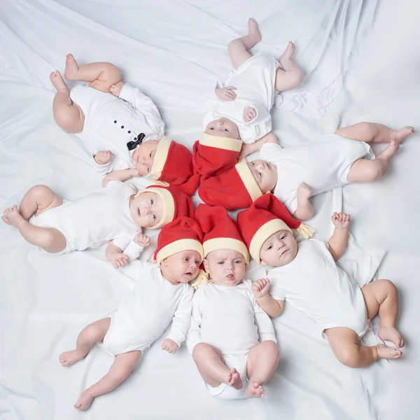 Bebés con sombreros de santa sobre fondo brillante — Foto de Stock