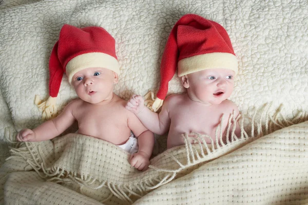 Babies with santa hats on bright background — Stock Photo, Image