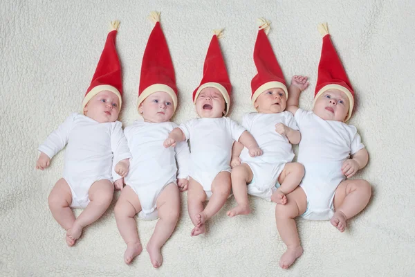 Babies with santa hats on bright background — Stock Photo, Image