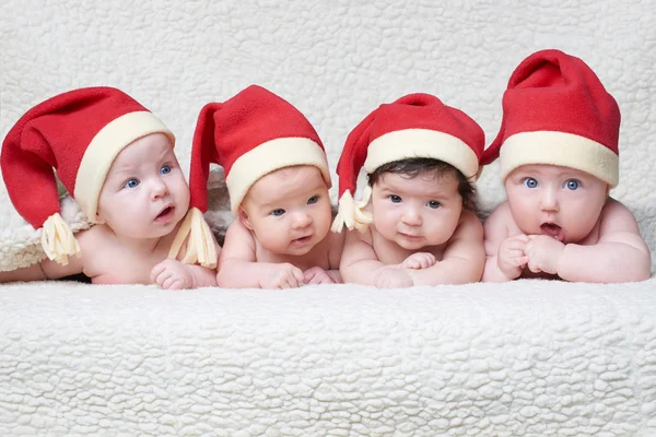 Малюки з капелюхами Санти на яскравому фоні — стокове фото