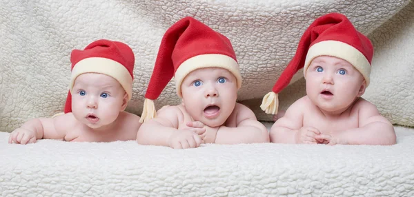 Bambini con Babbo Natale cappelli su sfondo luminoso — Foto Stock