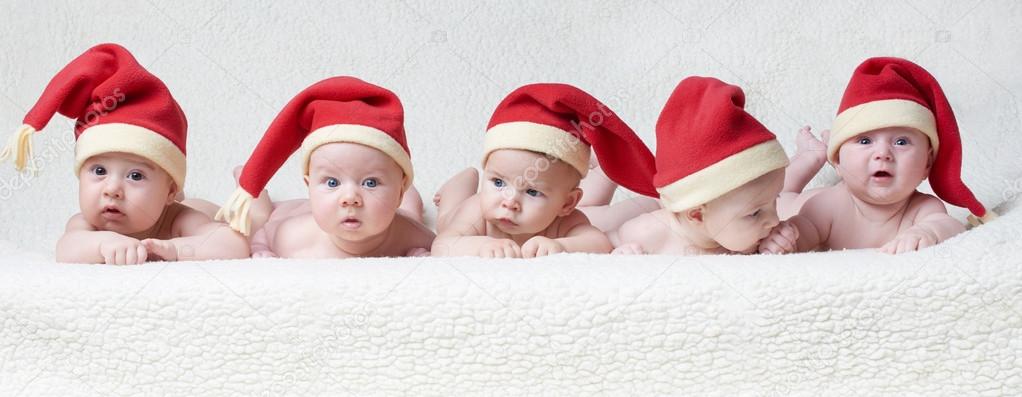 babies with santa hats on bright background