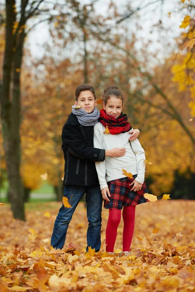 Fiú és lány őszi parkban — Stock Fotó