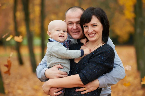 Famille dans parc d'automne sur feuilles jaunes — Photo