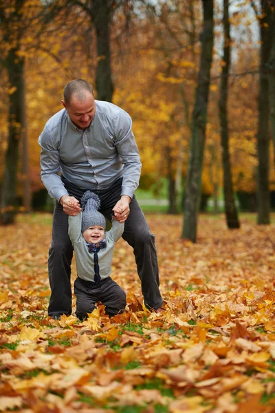 Padre con hijo caminando en el bosque de otoño — Foto de Stock