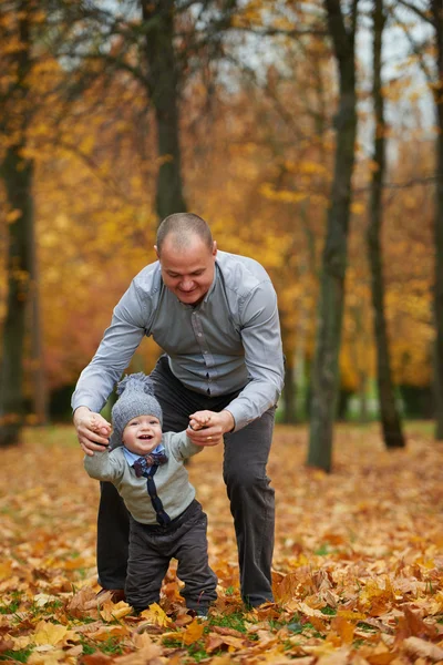 Vader en zoon wandelen in herfst woud — Stockfoto