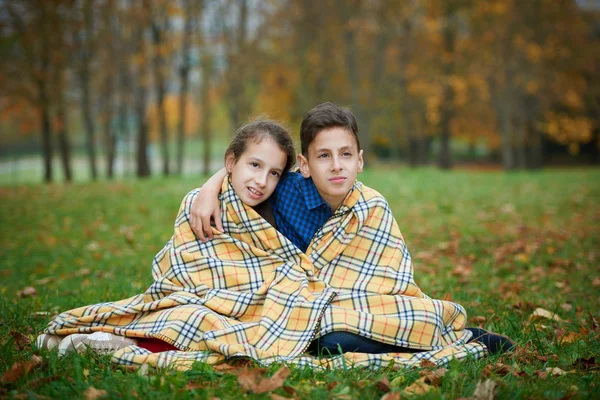 Pojke och flicka i höst park — Stockfoto