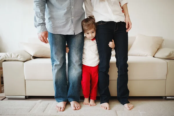 Ragazza abbracciando mamma e papà per le gambe — Foto Stock