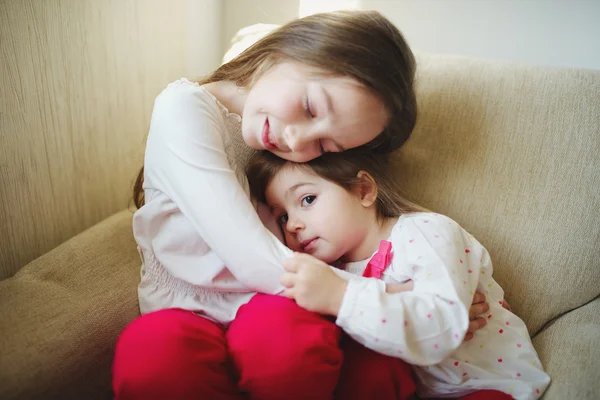 Flicka kramar hennes yngre syster — Stockfoto