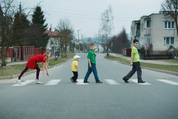 Дети переходят улицу на пешеходном переходе — стоковое фото