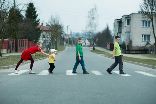 Bambini che attraversano la strada sul marciapiede — Foto Stock