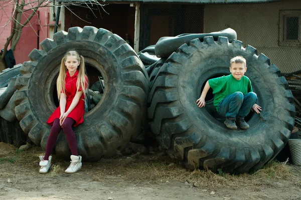 Crianças brincando em pneus de ferro-velho — Fotografia de Stock