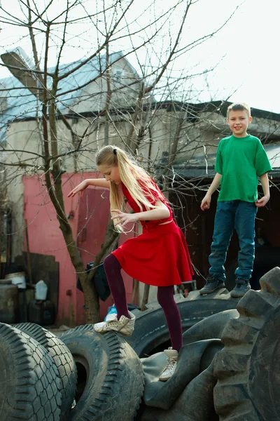 Děti si hrají v skládka pneumatik — Stock fotografie