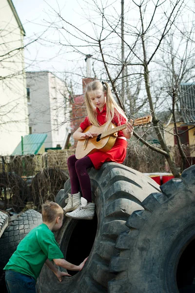 Kinder spielen in Schrottreifen — Stockfoto