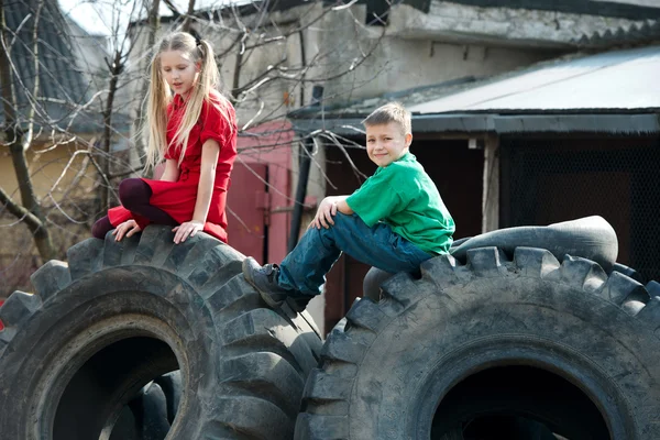 Niños jugando en neumáticos de desguace —  Fotos de Stock