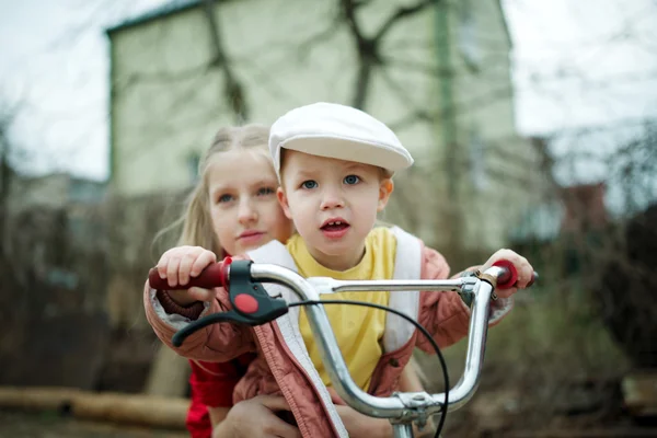 Дети катаются на велосипеде во дворе — стоковое фото