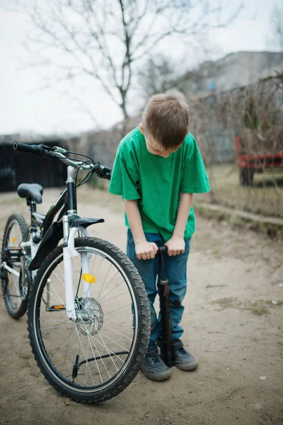 Menino bombas até sua roda de bicicleta — Fotografia de Stock