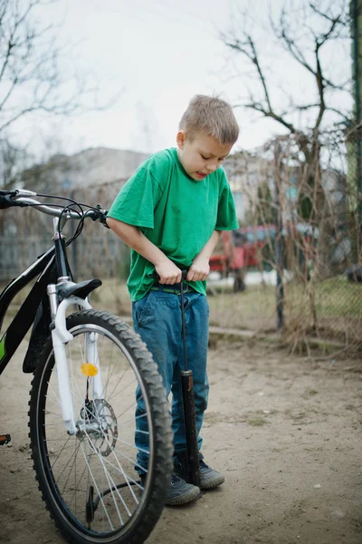 Chłopiec pompy się jego koła rowerowego — Zdjęcie stockowe