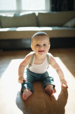 Yerde oturan sevimli küçük çocuk.
