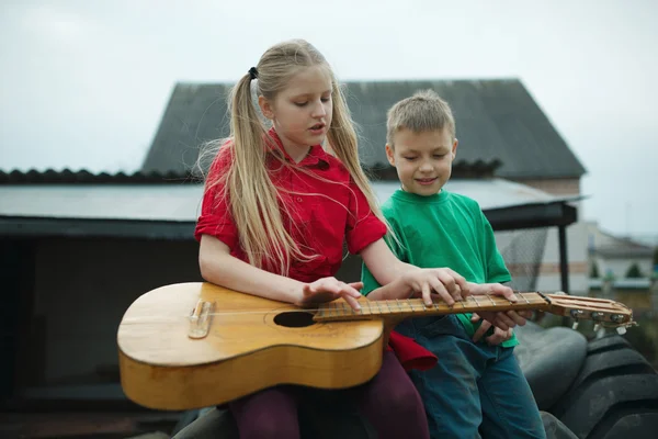 As crianças aprendem a tocar guitarra — Fotografia de Stock