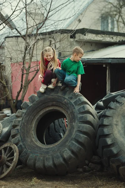 Crianças brincando em pneus de ferro-velho — Fotografia de Stock