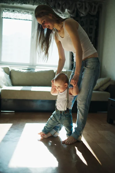 Belle mère enseigne bébé à marcher — Photo