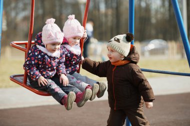 Çocuk kızlar salıncağa alır.