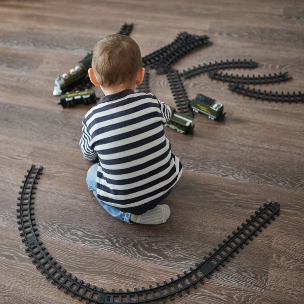 Mały chłopiec buduje zabawki kolejowe — Zdjęcie stockowe
