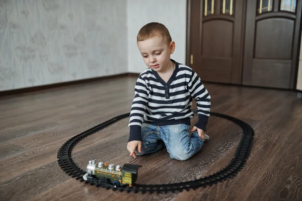 Маленький хлопчик будує іграшкову залізницю — стокове фото