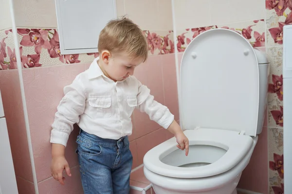 Petit garçon regarde dans les toilettes — Photo