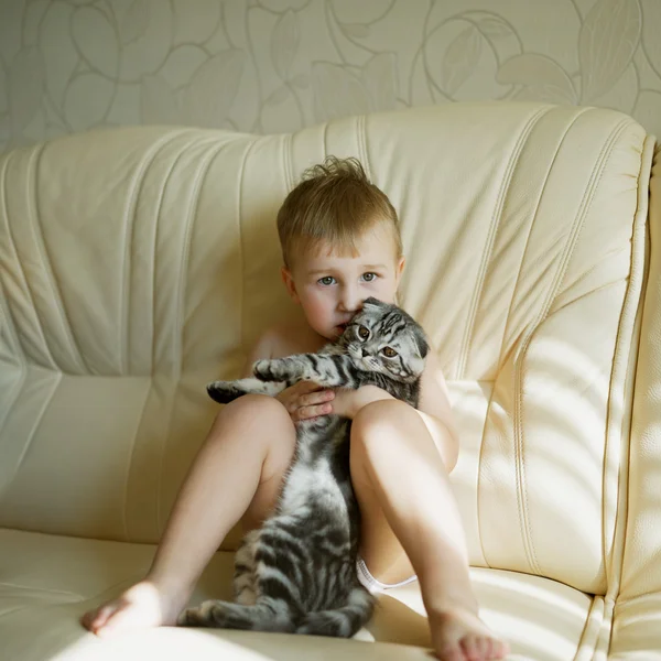 Piccolo divertente ragazzo abbraccia gatto — Foto Stock