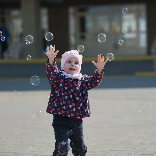 Маленькая девочка играет с пузырьками — стоковое фото