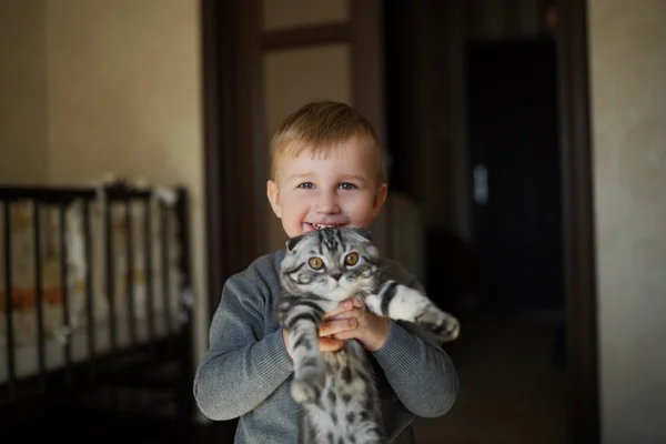 Pequeño divertido chico abraza gato — Foto de Stock