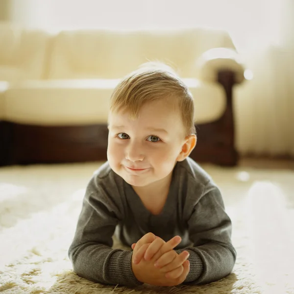 Niño pequeño acostado en la alfombra — Foto de Stock