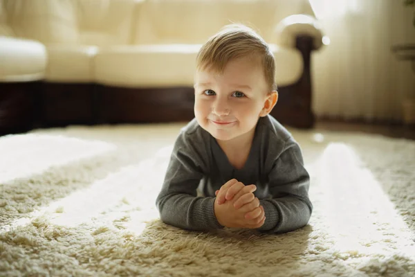 Niño pequeño acostado en la alfombra — Foto de Stock