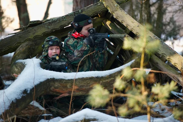 Garçons jouer avec pistolet pendant laser tag — Photo