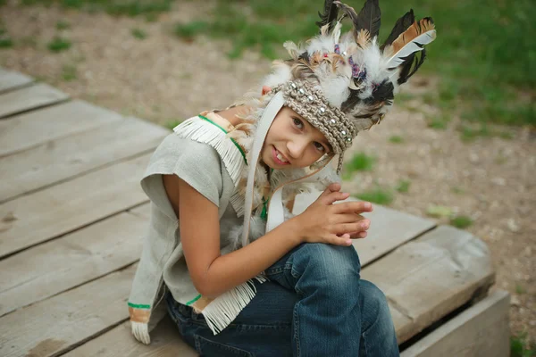 Pequeño chico divertido con traje americano nativo — Foto de Stock