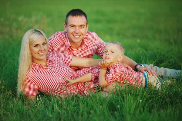 Família feliz na grama verde — Fotografia de Stock