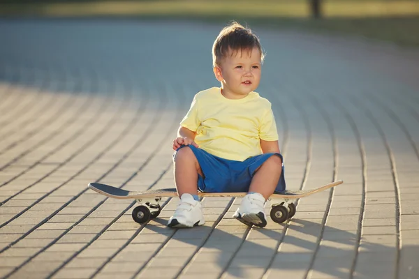 Милый маленький мальчик со скейтбордом на открытом воздухе — стоковое фото