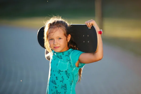 Roztomilá holčička s skateboardem — Stock fotografie