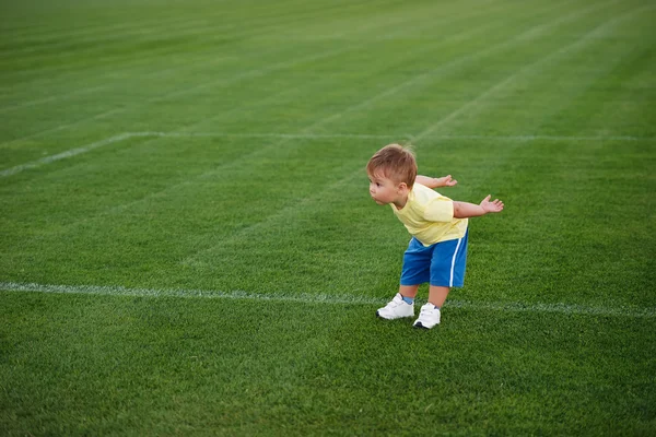 Liten rolig pojke på fotbollsstadion — Stockfoto