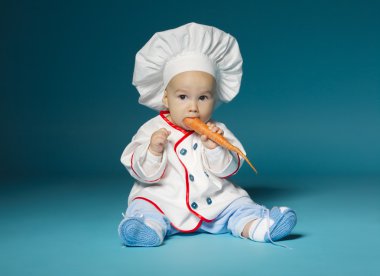 aşçı kostümü ile komik bebek havuç tutar