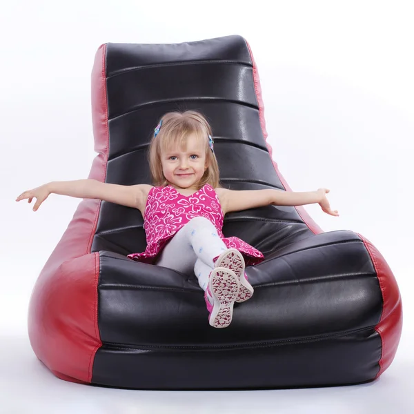 Girl sitting on a soft modern chair — Stock Photo, Image